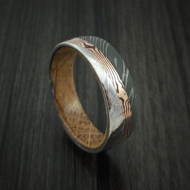 Damascus Steel Men's Ring with Diagonal Rose Gold Mokume Shakudo Inlay and Whiskey Barrel Wood Sleeve Custom Made